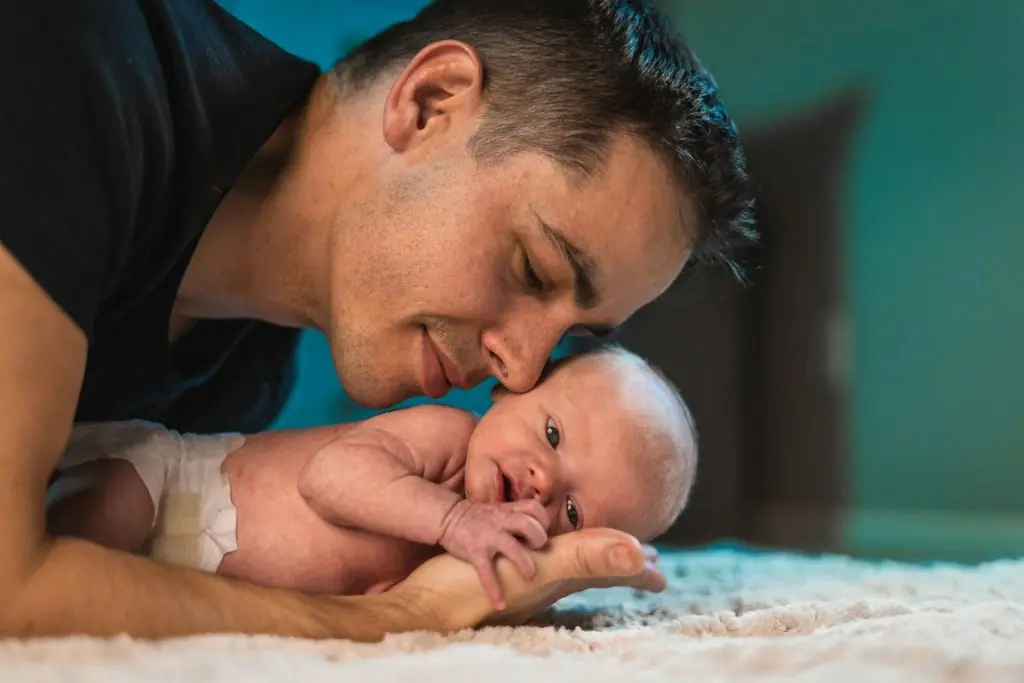 Blog - 1. Concediu paternal - tată, bebeluș, covor alb, pampers, tricou negru